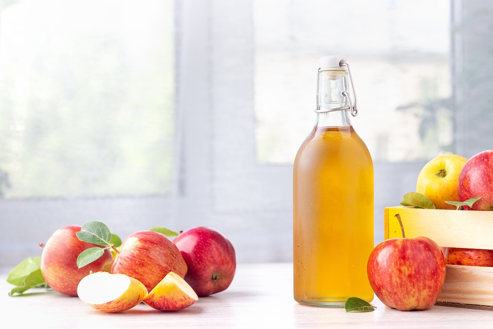 Apple cider vinegar on a table in a fermentation bottle.